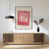 A framed poster with a minimalistic design featuring two hands making a pinky promise, set against a beige background with pink borders. The text "always & forever" is written at the bottom. The poster is hung above a wooden sideboard with decorative items and a modern pendant light.
